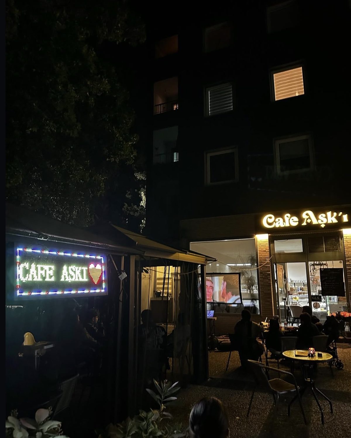Außenbereich des Café Aşk-ı am Abend mit Leuchtschild